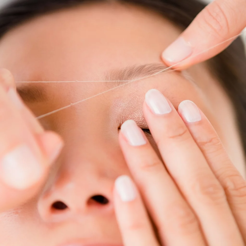Close-up of eyebrow threading treatment at Etica Beauty