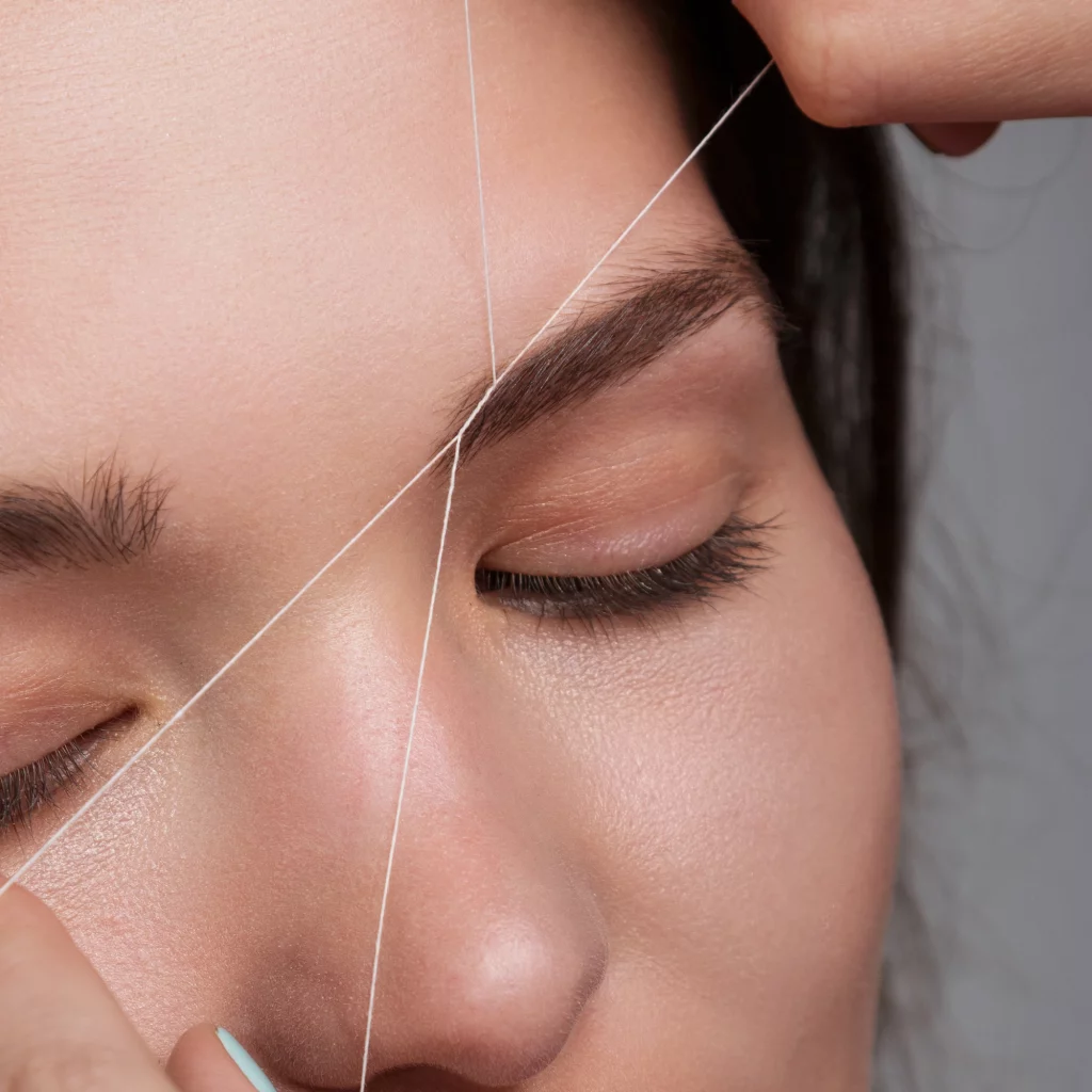 Extreme close-up of eyebrow threading at Etica Beauty